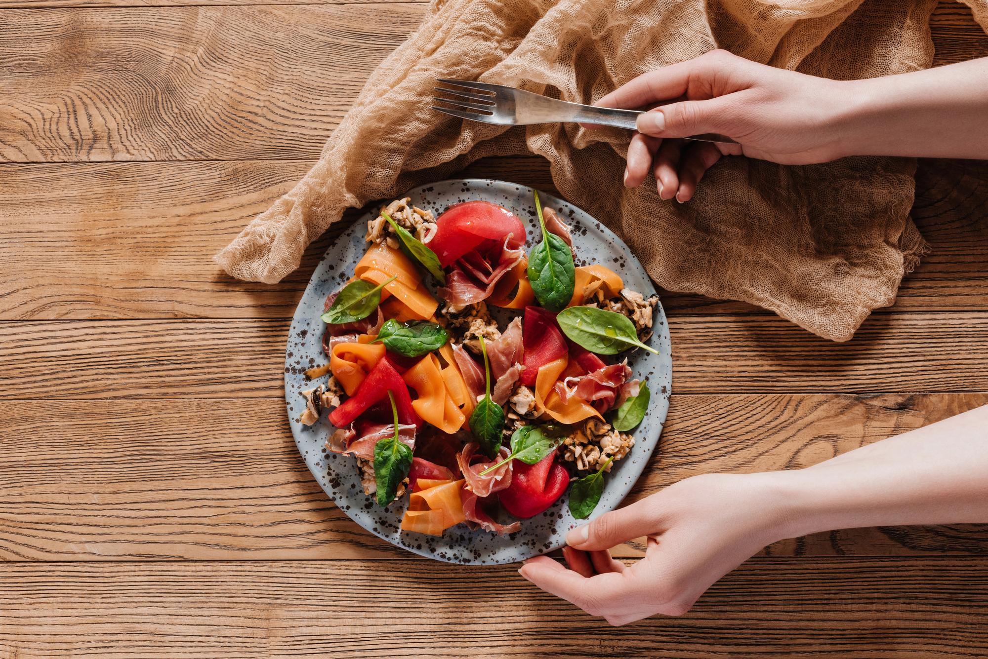 Hands plating roasted vegetables